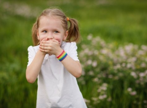 Child covering their mouth with their hands