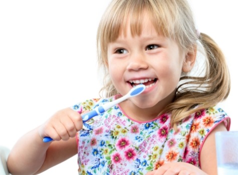 Young girl with pigtails brushing her teeth