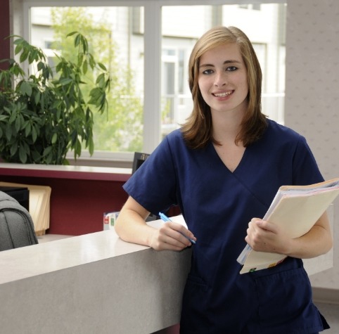 Smiling Hoover dental team member standing by front desk