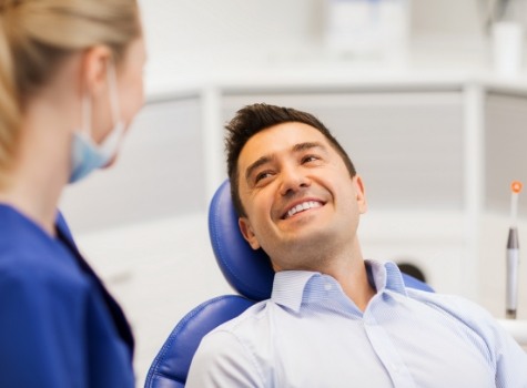 Man in dental chair smiling at dentist