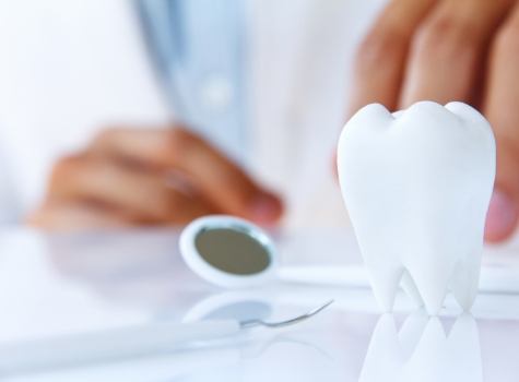 Dental exam tools next to model of tooth on table