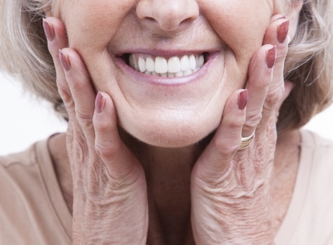 Close up of smiling senior woman touching her cheeks