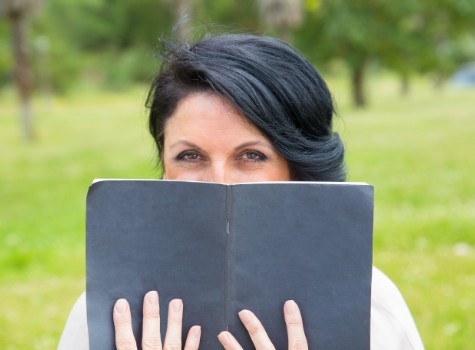 Woman reading a book in a grassy field
