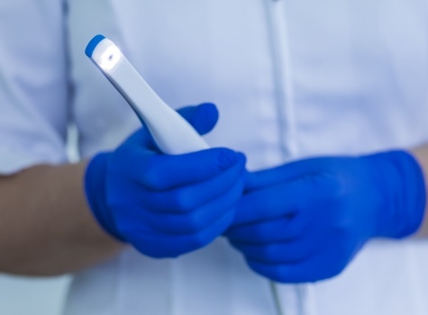 Gloved hands holding an intraoral camera