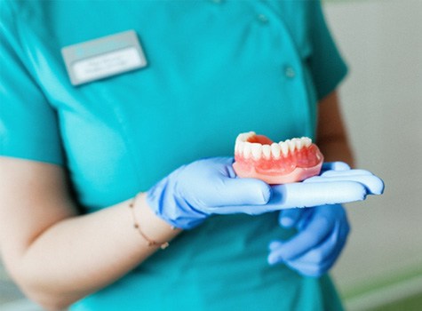 Dentist holding a denture in their hand