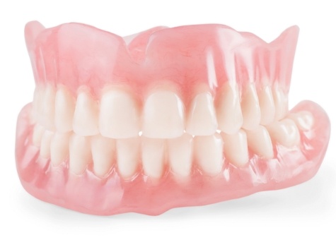 Set of full dentures against white background