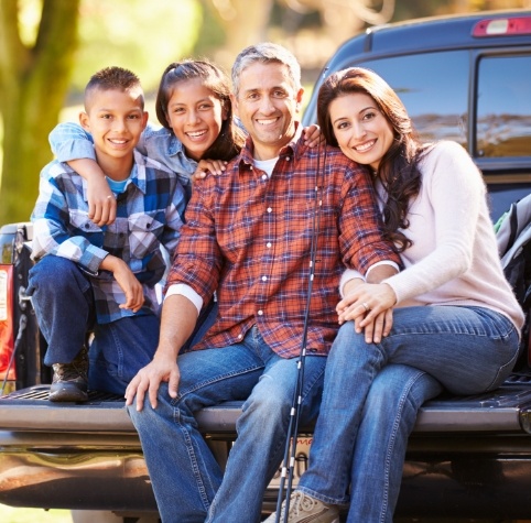 Family of four sitting in truck bed after visiting family dentist in Hoover