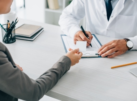 Dental patient handing a payment card to dentist