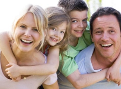 Family of four smiling outdoors