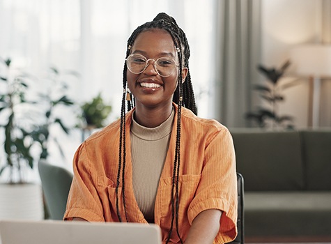 Woman smiling while working on laptop
