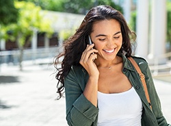 Woman smiling while talking on phone outside