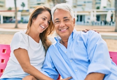 Laughing man and woman sitting on couch together