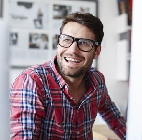 Man in red plaid shirt smiling after preventive dentistry in Hoover