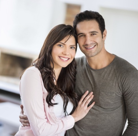 Man and woman hugging after restorative dentistry in Hoover