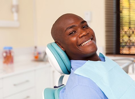 Man leaning back in dental chair and smiling