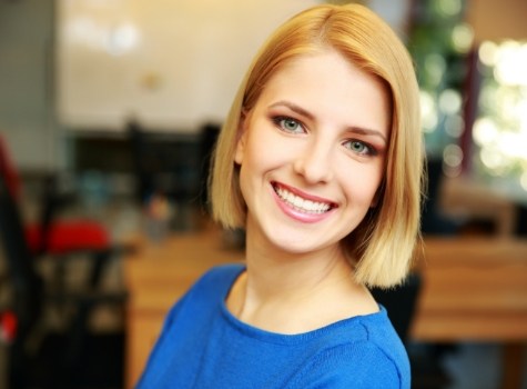 Smiling blonde woman in dark blue blouse