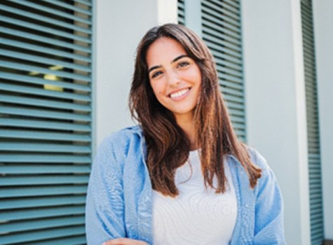 Woman with white teeth smiling while standing outside