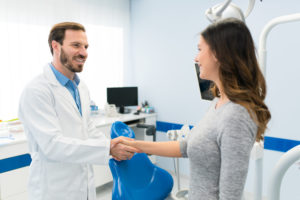 Dentist shaking hands with patient