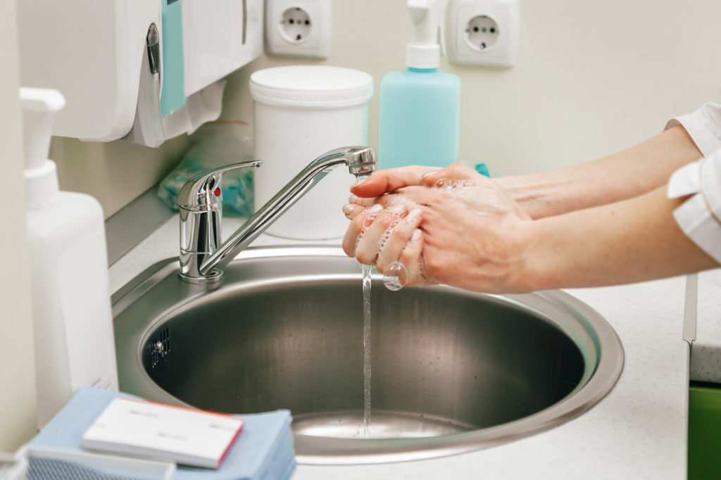 Dentist in Hoover washes their hands.