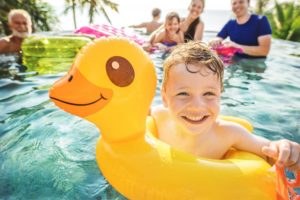 Boy in pool smiles after visiting his Hoover children's dentist