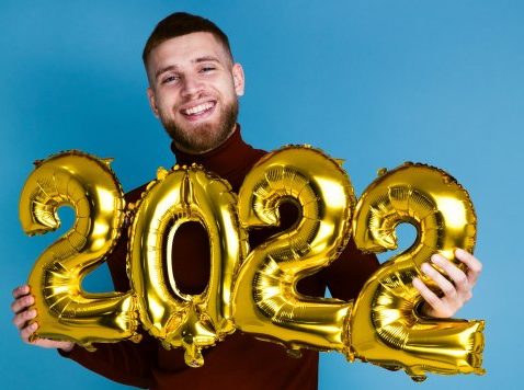 man with 2022 new year’s balloons  