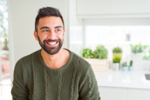 a person sitting in their kitchen and smiling