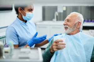 a patient and dentist smiling and discussing health factors