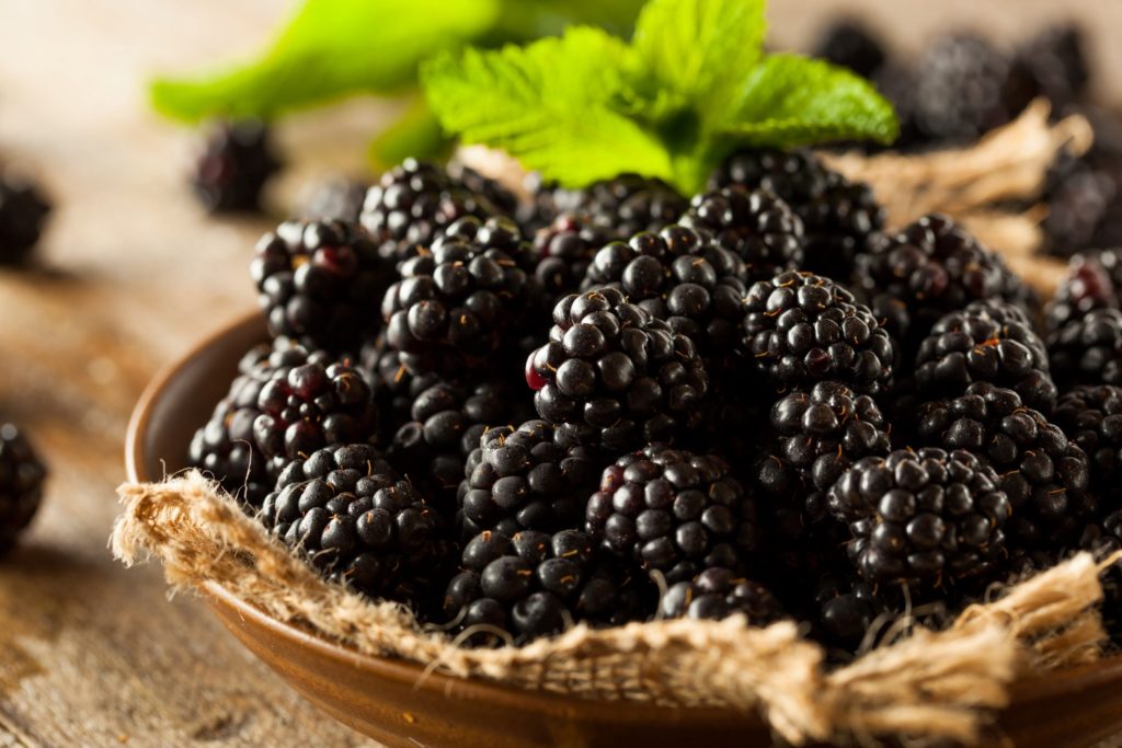 Bowl of blackberries on wood table