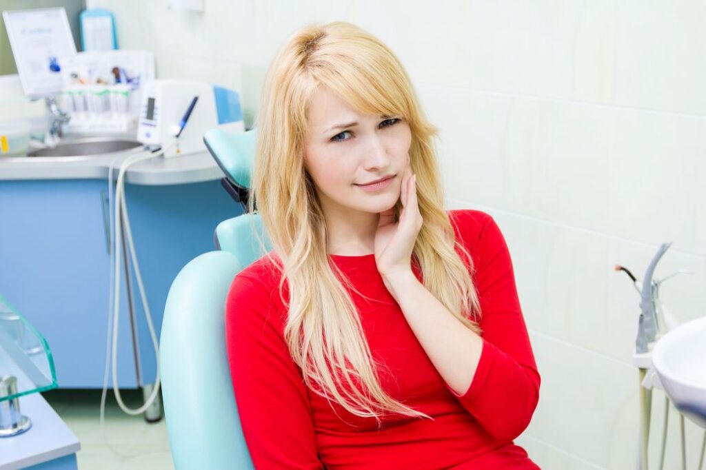 A woman with a toothache sitting in a dental chair