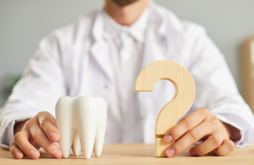 Dentist holding tooth and question mark